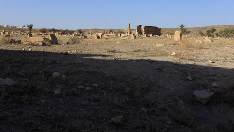 Deserted-ancient-Sbeitla-Roman-ruins-under-clear-blue-sky-in-Tunisia,-evoking-a-historical-atmosphere