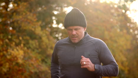 mature man running through autumn landscape in slow motion