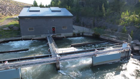 a beautiful drone close up of a small hydro electric plant creating and generating electricity at a dam in island park