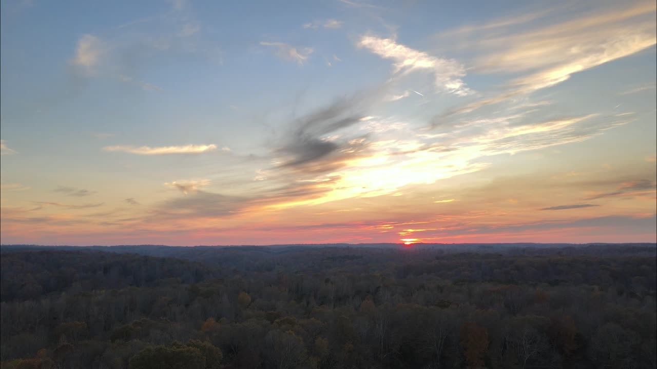 Slow descending aerial footage of a fiery sunset in the beautiful countryside