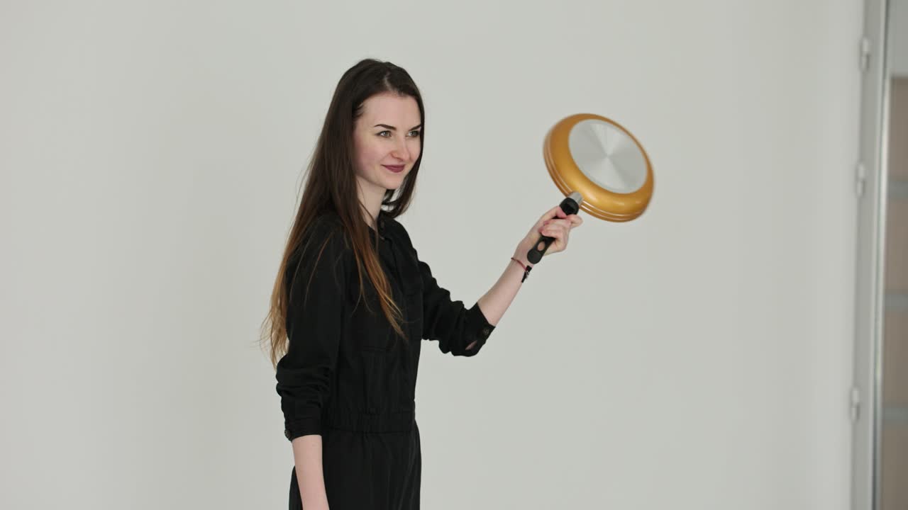 Woman in Black Outfit with Frying Pan