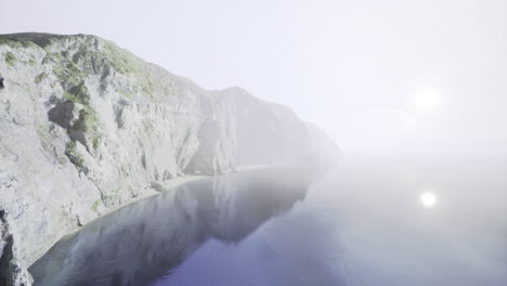 misty coastline at dawn with cliffs and calm waters in serenity