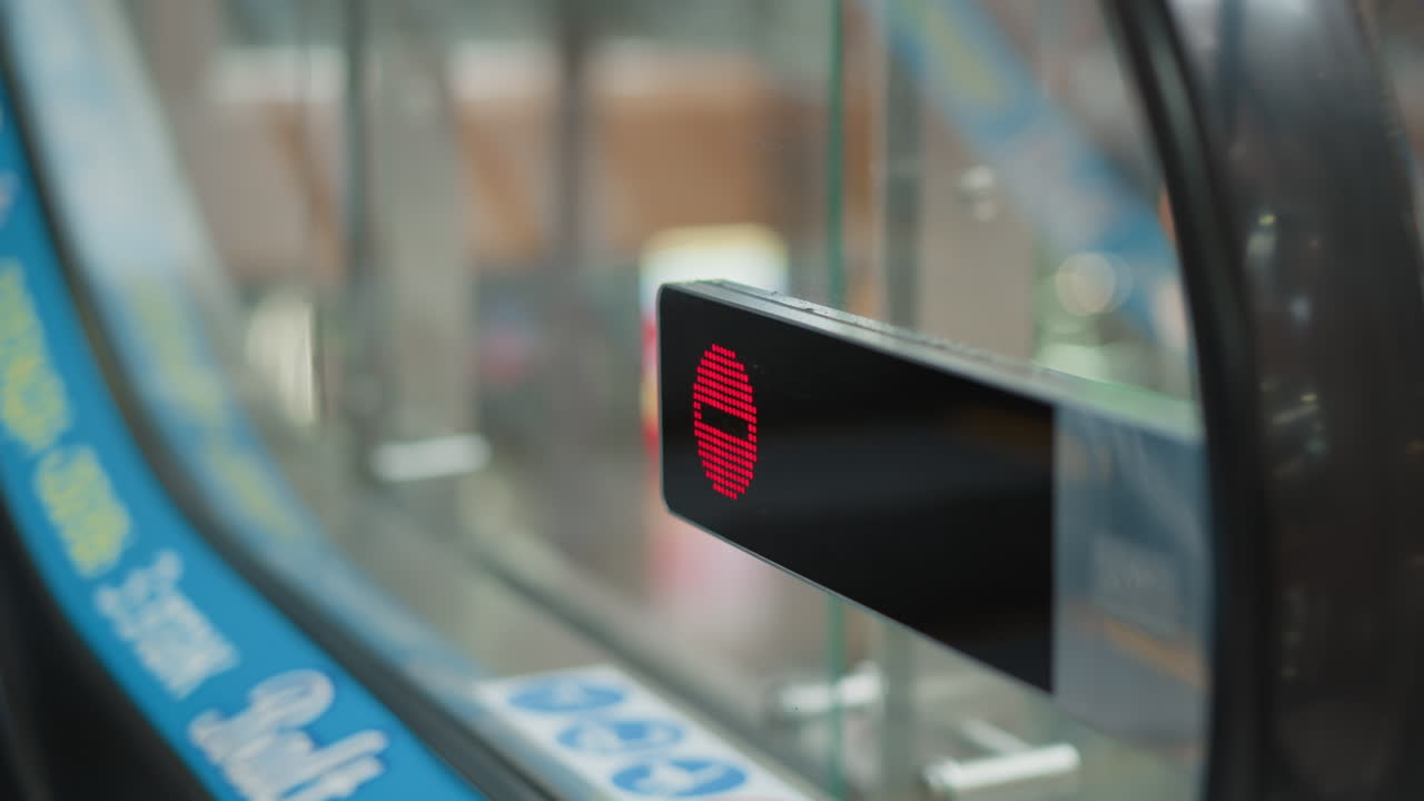 red stop indicator lights up on glass entrance panel of moving walkway as shopper steps off onto shiny mall floor with blurred shoppers and ambient lighting in modern retail environment