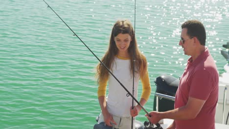 Side-view-of-a-Caucasian-man-and-his-teenage-daughter-holding-fishing-rods