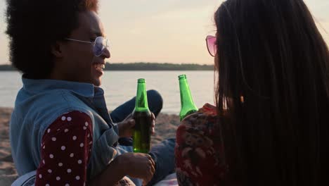 pareja bebiendo cerveza y viendo la puesta de sol en la playa/dabrowa gornicza/polonia