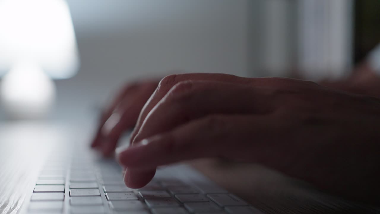close up hands working overtime typing research laptop office desk at night