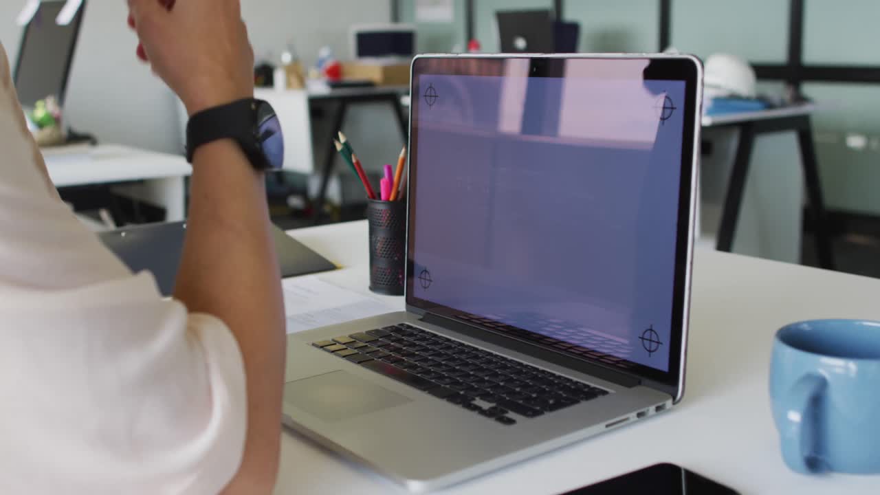 mujer de negocios caucásica sentada en un escritorio y usando una computadora portátil con espacio de copia en la pantalla