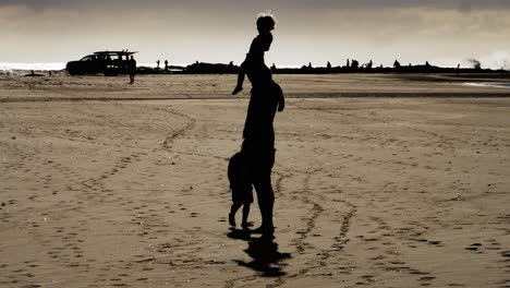 Vater-Und-Kinder,-Die-Sich-An-Einem-Sommertag-Am-Strand-Treffen---Leute-Beobachten-Extreme-Wellen,-Die-Im-Hintergrund-Plätschern---Schnapperfelsen-Am-Südlichen-Ende-Der-Rainbow-Bay-In-Gold-Coast,-Qld---Vollbild