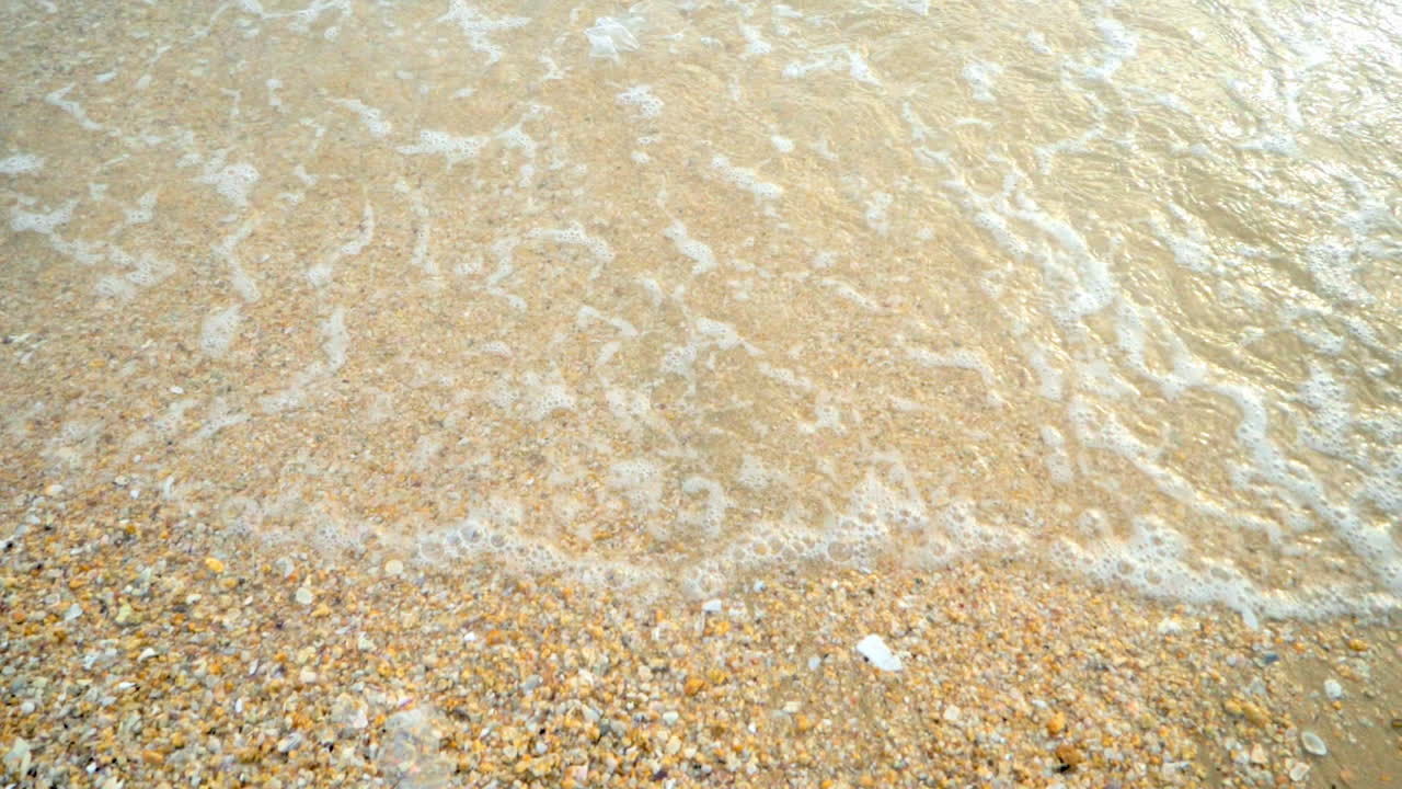 해가 지는 동안 열대 지방의  ⁇  모래 해변의 해안에 도달하는 파도와 함께 아름다운 해변