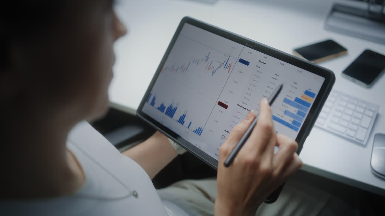 Woman Analyzing Financial Data on Tablet