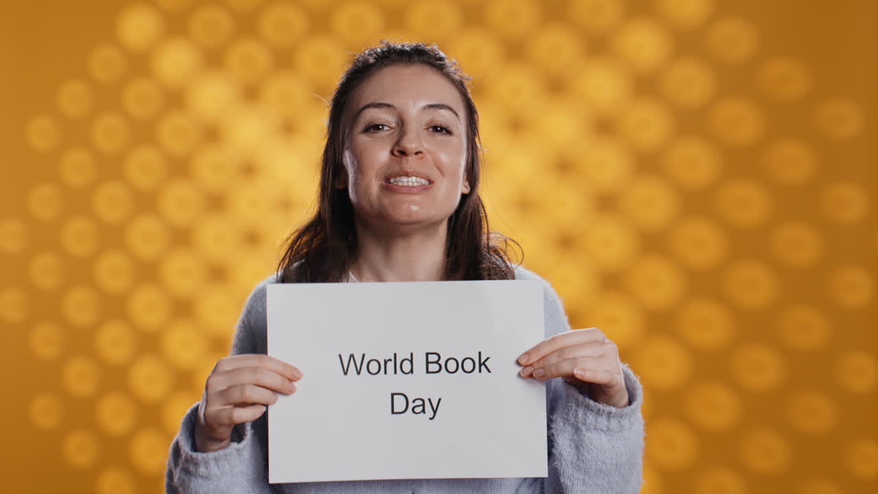 miembro del club del libro sonriente sosteniendo un cartel con el mensaje del día mundial del libro