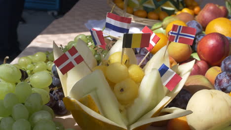 Frutas-Arregladas-En-La-Mesa-Y-Banderas-De-Alemán,-Ruso,-Suizo,-Inglés-Y-Francés