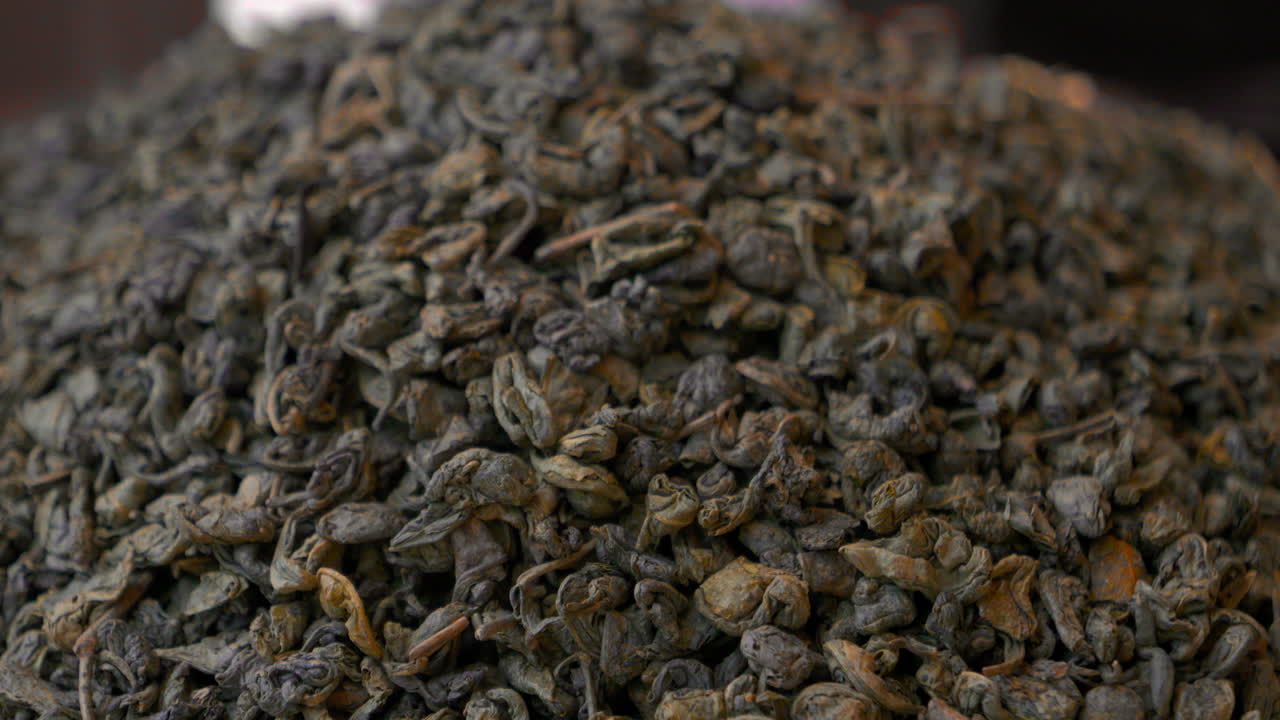Macro video of loose leaf tea with dry curled leaves rich texture natural organic tea product for beverage preparation market and tea culture concept themes of tea culture traditional markets