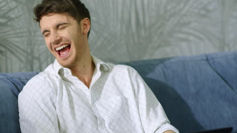 Laughing-guy-receiving-great-news-on-computer-indoors.-Excited-man-using-laptop