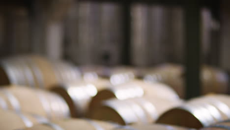 rows of barrels in a modern wine factory warehouse