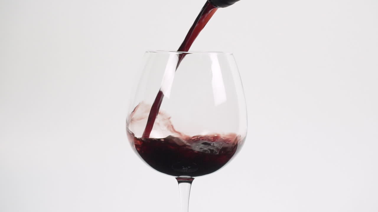 el vino tinto se vierte en un vaso de borgoña