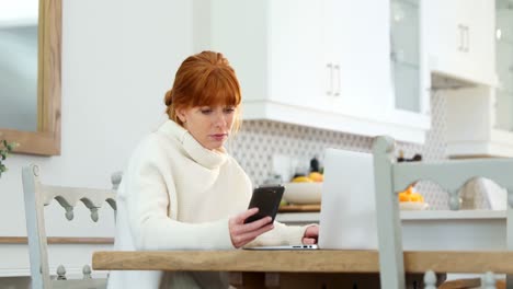Beautiful-woman-using-mobile-phone-and-laptop-while-having-coffee-4k
