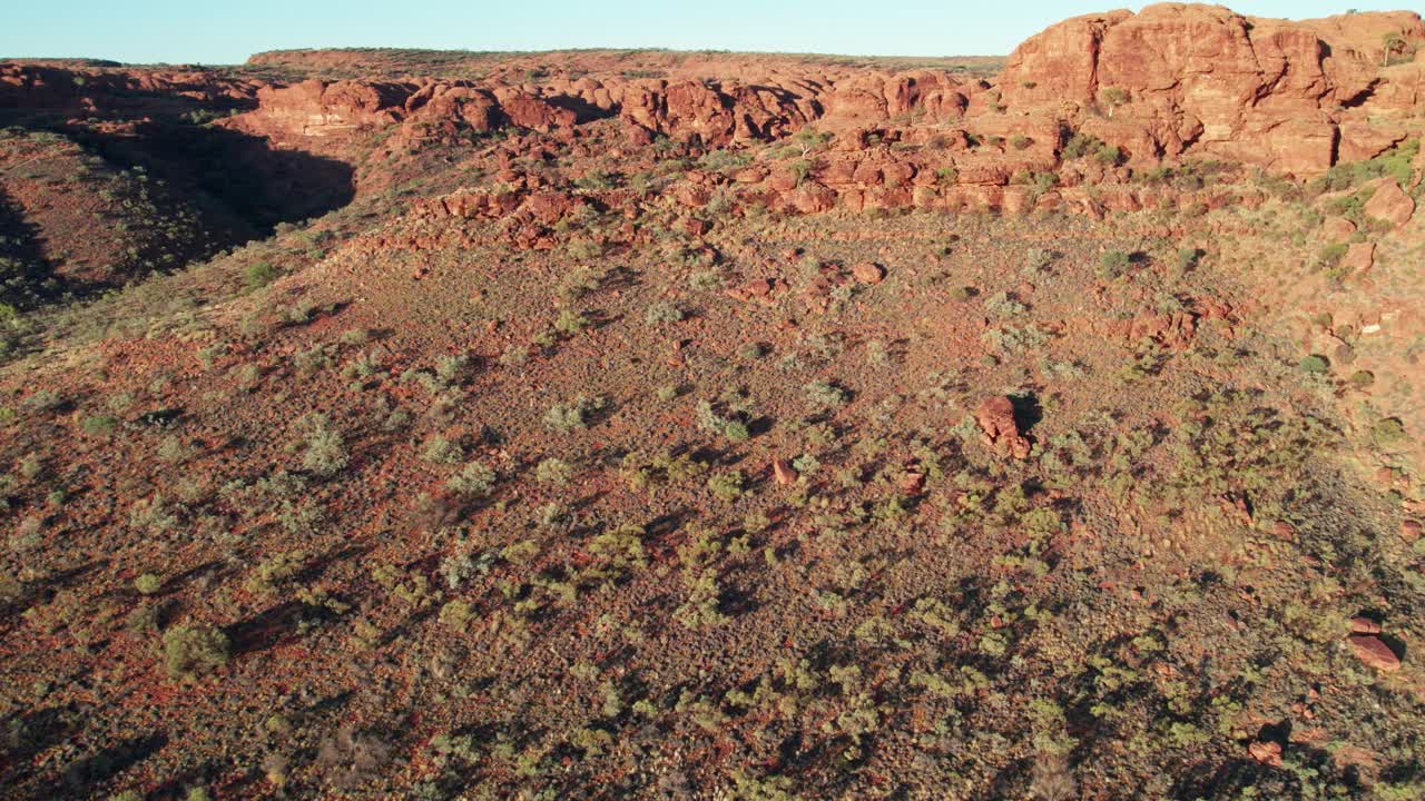 Reversing aerial view of the ridges near Kings Canyon, Watarrka, in the Northern Territory, Australia. August 2022.