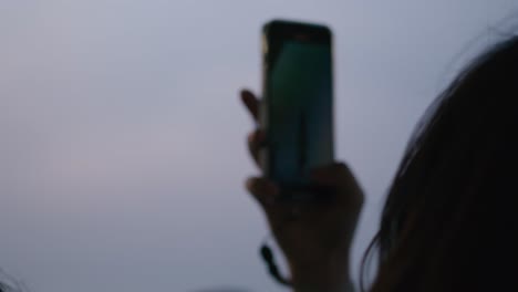 Phone-silhouetted-against-Burano's-dusk-sky,-Venice