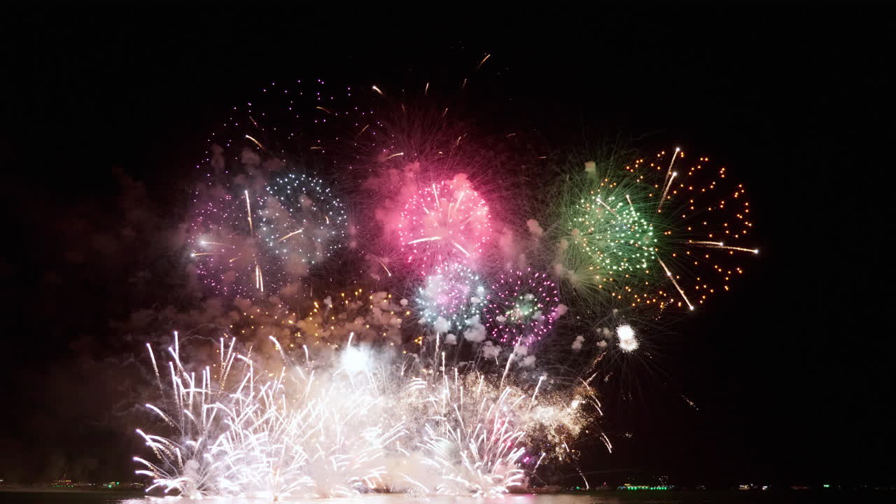 el lanzamiento sistemático de fuegos artificiales desde bajas a altas altitudes revela un clímax a una extraordinaria exhibición de chispas y llamas de colores con luces bokeh en el cielo nocturno