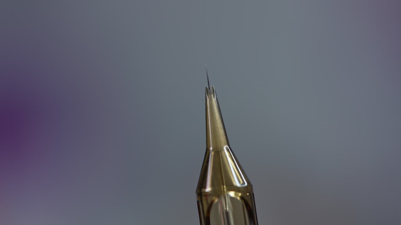 The cosmetologist checks the needle. Preparation of the needle before eyebrow tattooing