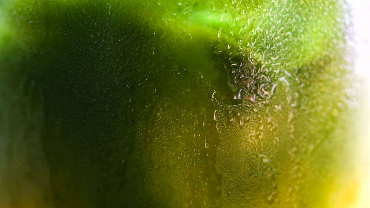 Close up of a glass of an iced orange juice matcha on a table at a cafe