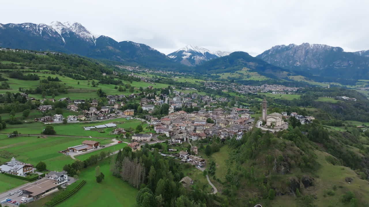 Aerial footage of the town Castello-Molina di Fiemme in Italy rotating around the Chiesa di San Giorgio Church.