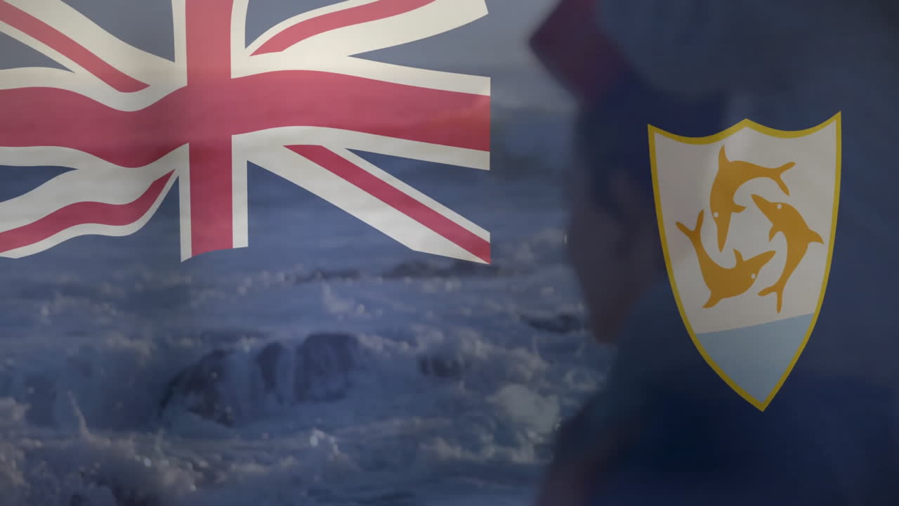 Waving British and Anguilla flags over ocean waves in background