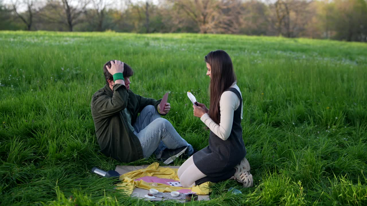 Couple Playing Cards in a Park