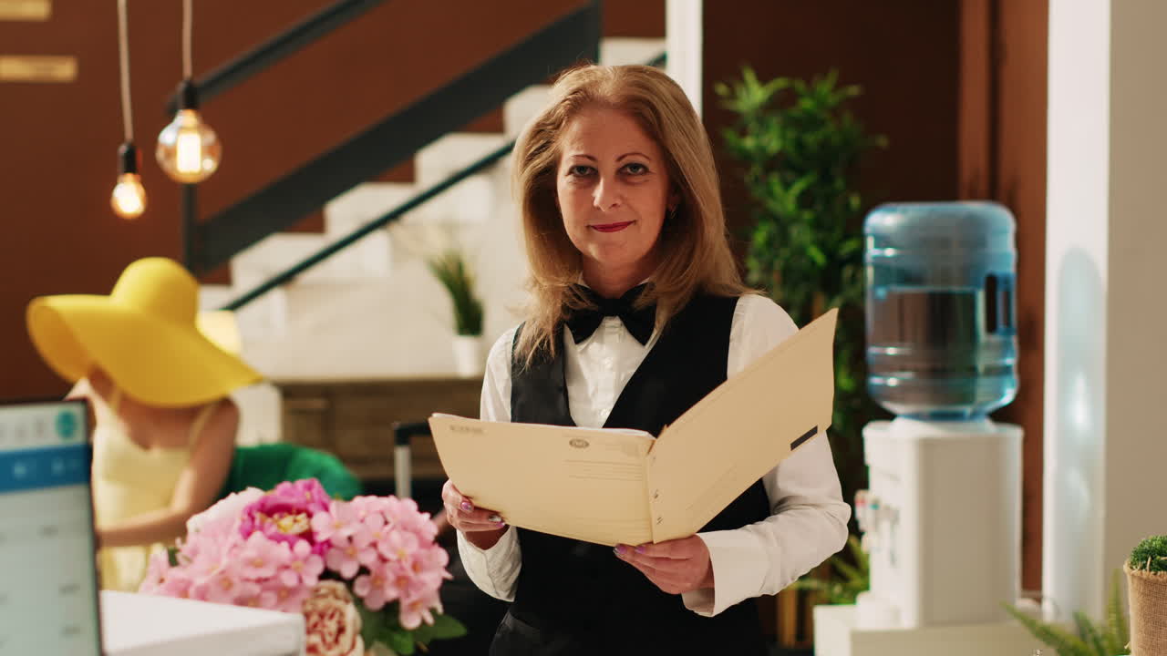 el conserje del hotel revisa las reservas.