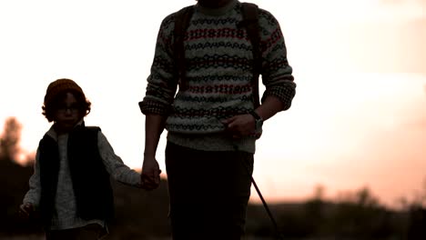 father and son walking on nature footpath with dog