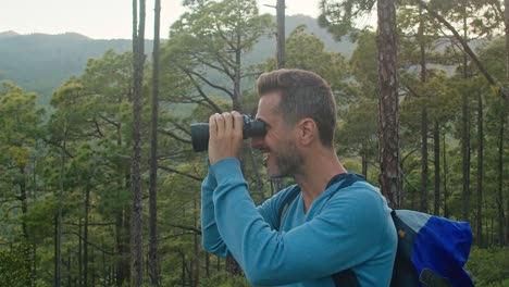 hombre feliz admirando la naturaleza a través de binoculares