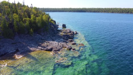 drone shot of blue clearly water in the coast of georgian bay, ontario, canada