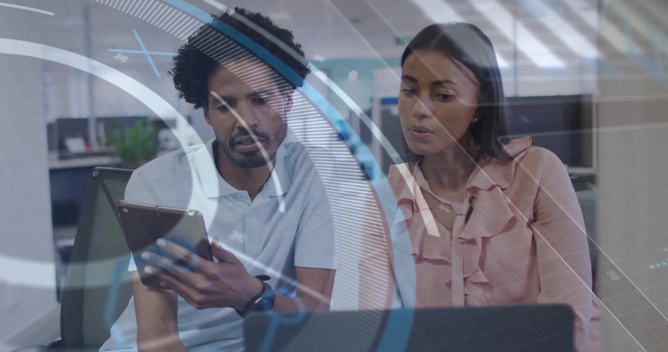 Man tilting tablet toward woman colleague at desk, swiping screens with data overlays for review