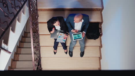 Top-view-of-company-manager-arguing-businessman-on-stairs