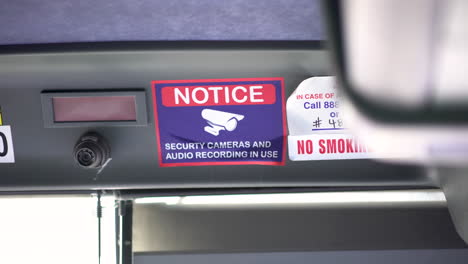 quick 4k glimpse at a generic security camera warning sign on a public bus in california