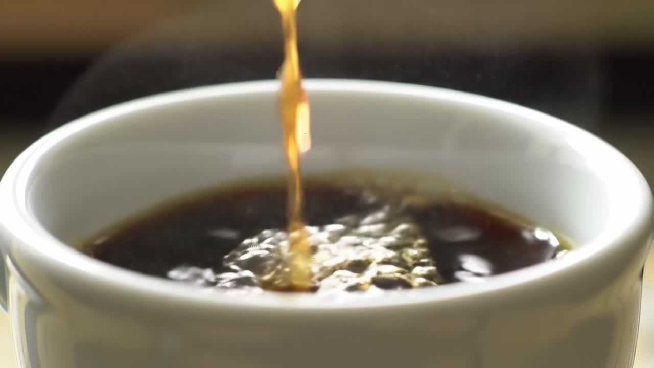 A mesmerizing close-up of hot coffee being poured into a white mug, capturing the rich, dark liquid as it swirls and bubbles, highlighting the aromatic steam rising above