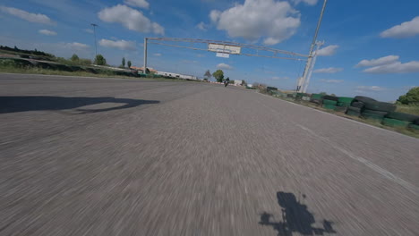 drone fpv volando por el hipódromo de lleida pasando motociclistas vista aérea subiendo sobre el circuito