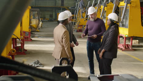 engineers shaking hands and talking during visit to factory