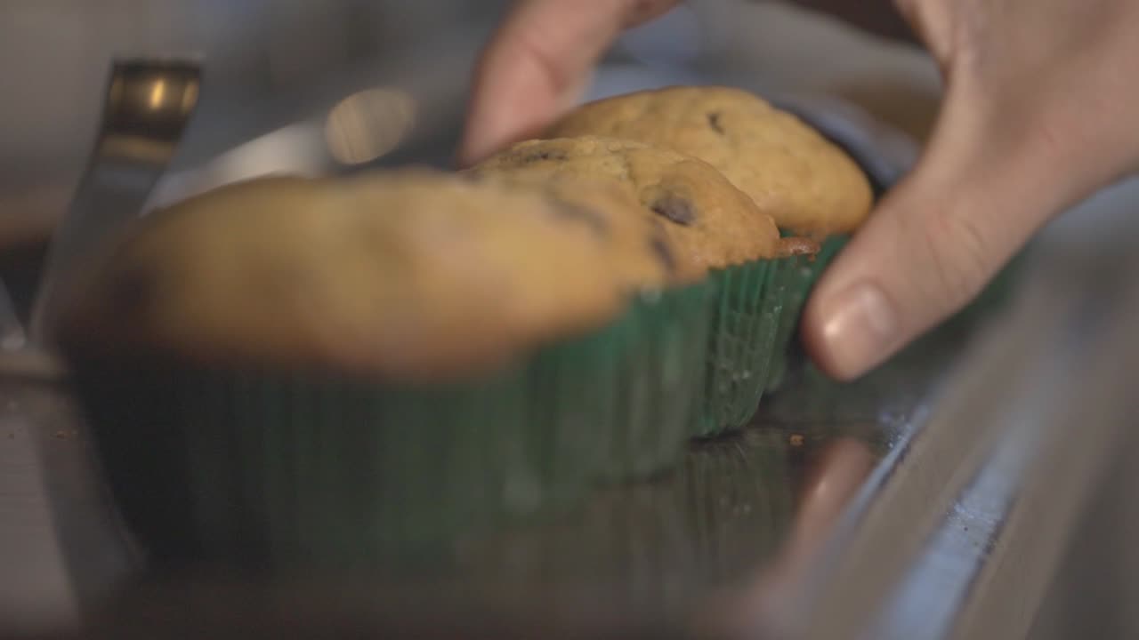Un uomo prende un gustoso muffin fatto in casa - Primo piano