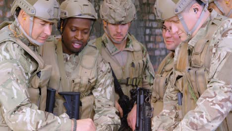 Front-view-of-mixed-race-military-soldiers-with-gun-planning-during-military-training-4k