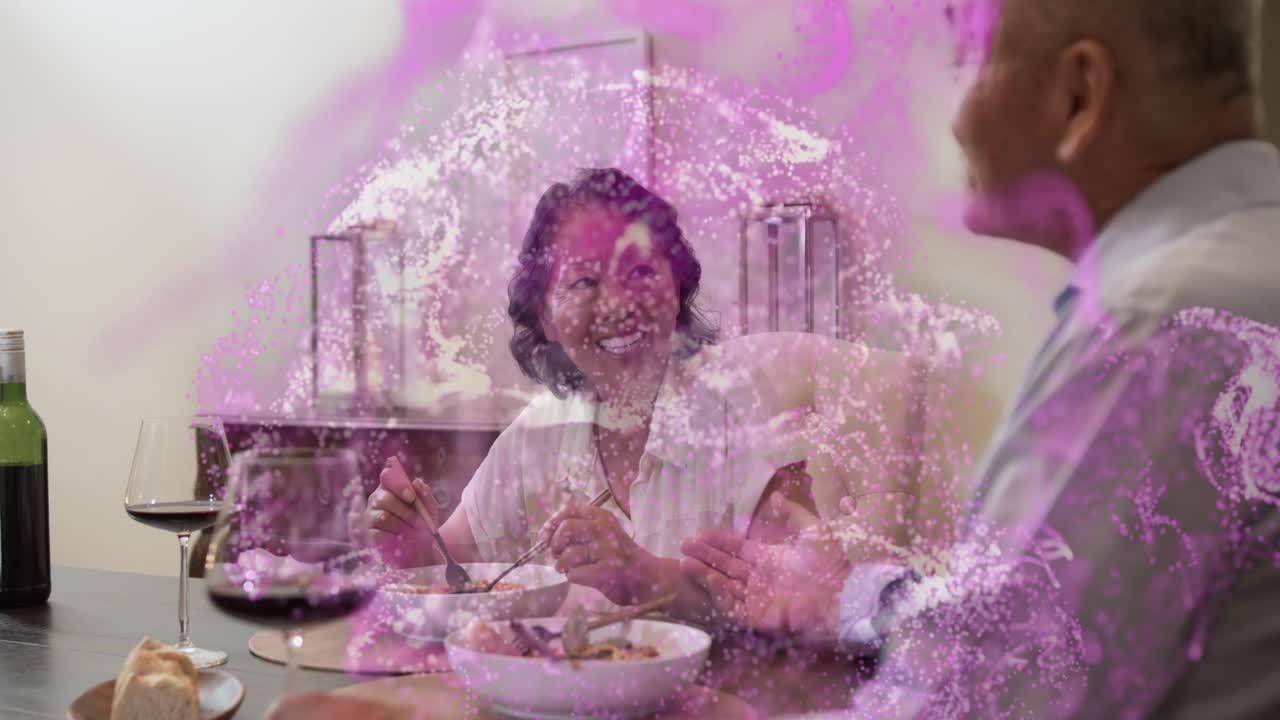 Woman starting eating, laughing as man gesturing at table, pink overlay highlighting meal talk