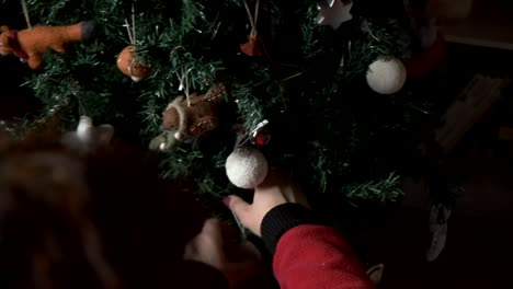 mujer decorando un árbol de navidad con decoración de árbol de fieltro 4k
