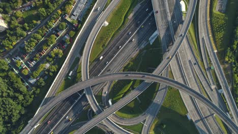 intercambio de carreteras de varios niveles y tráfico de coches. drone está girando y volando hacia arriba. disparo vertical aéreo.