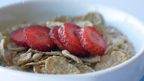 strawberry and corn flakes in a bowl on table ,