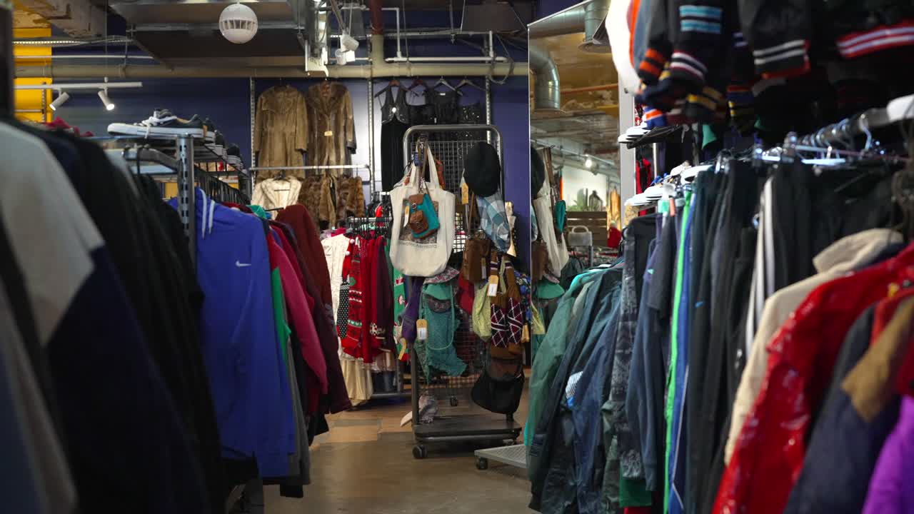 A vintage clothing shop in East London with colorful clothes on rails, tot bags, eclectic fashion experience