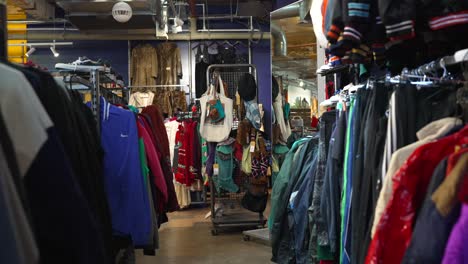 a vintage clothing shop in east london with colorful clothes on rails, tot bags, eclectic fashion experience