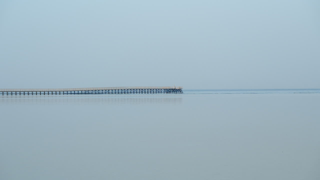 샤름 엘 셰이크의 잔잔한 바다에 반사된 빈 목조 부두