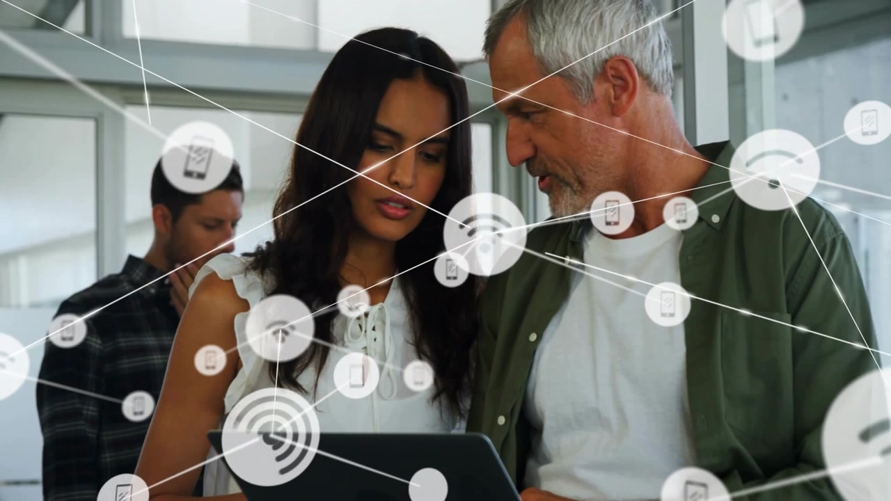 Woman holding tablet man leaning in pointing and showing tech connection as WiFi nodes expanding