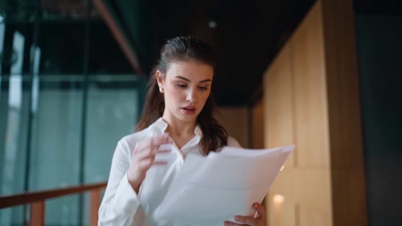 Tensed accountant reviewing papers walking office building hallway closeup